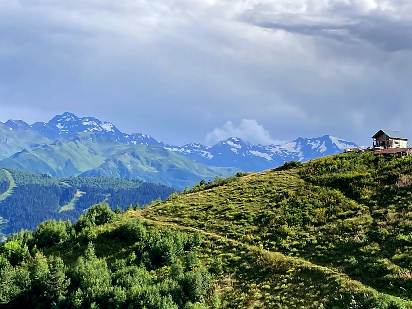 Blick auf das Kaukasus-Gebirge mit Berghütte im Vordergrund.