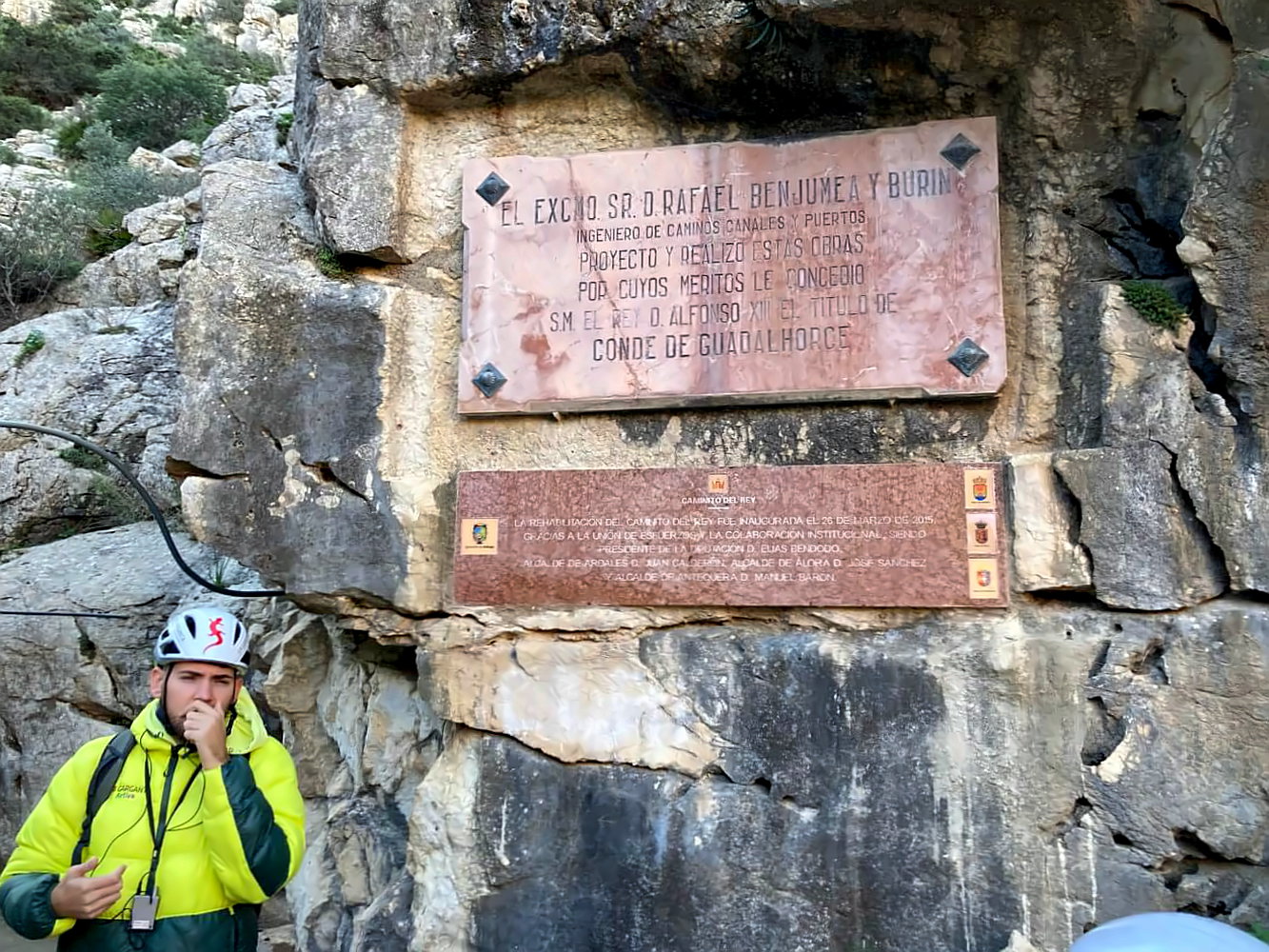 Führer mit Mikrofon unter einem Schild am Start der Wanderung.