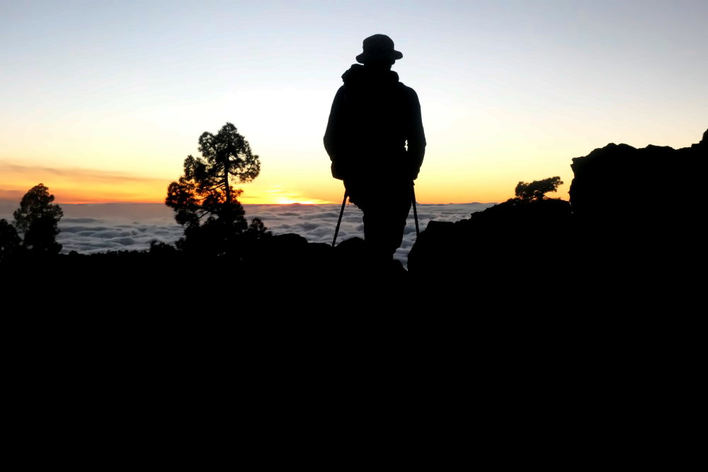 Wanderer beim Sonnenuntergang über den Wolken auf Teneriffa.