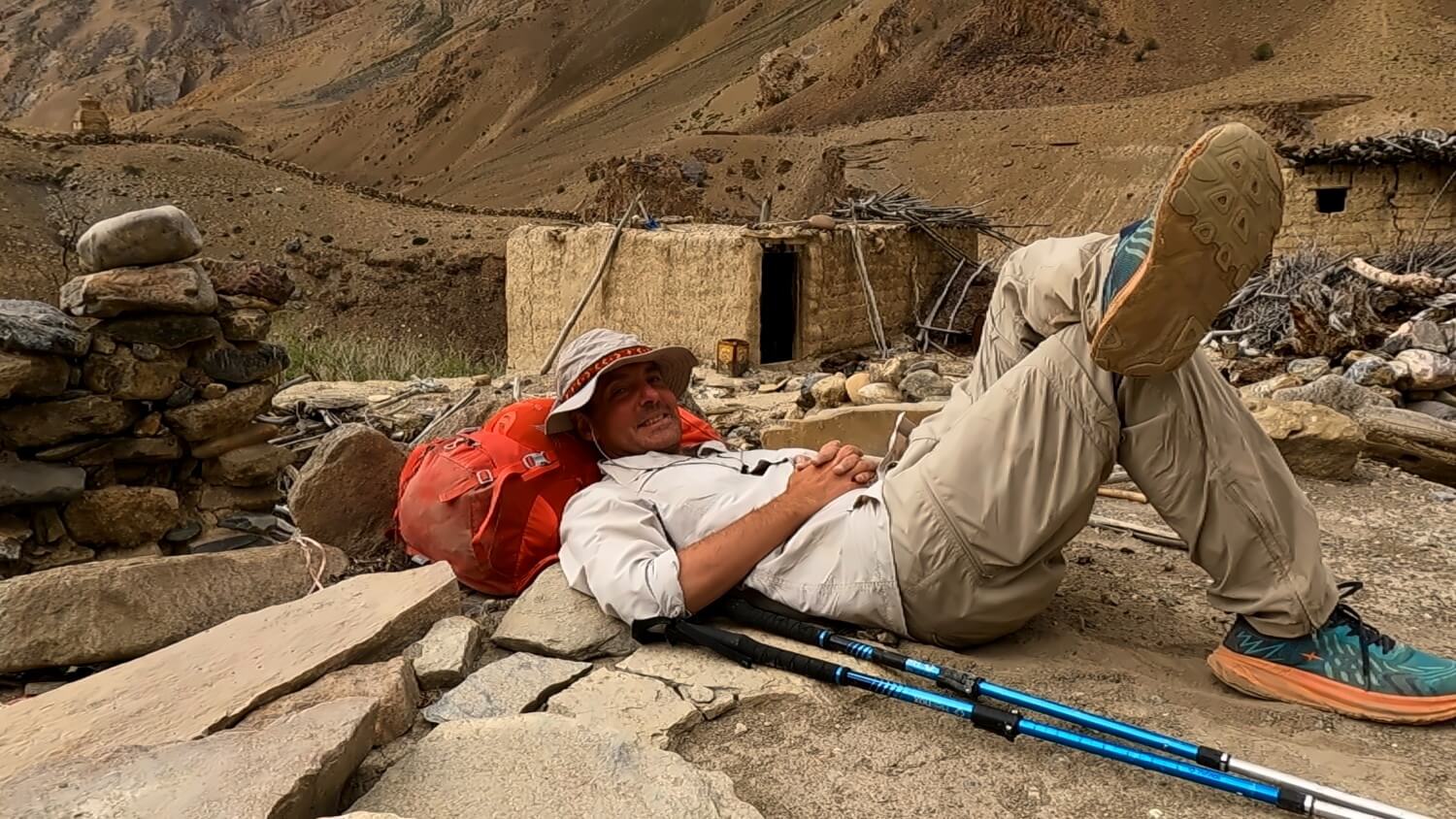 Trekker macht eine Pause und lehnt sich an seinen Rucksack.