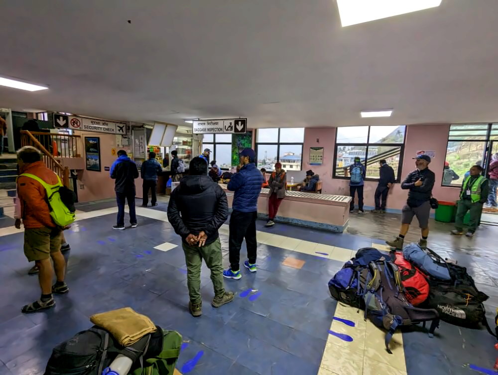 Gepäckaufgabe und Trekker im Flughafen Lukla.