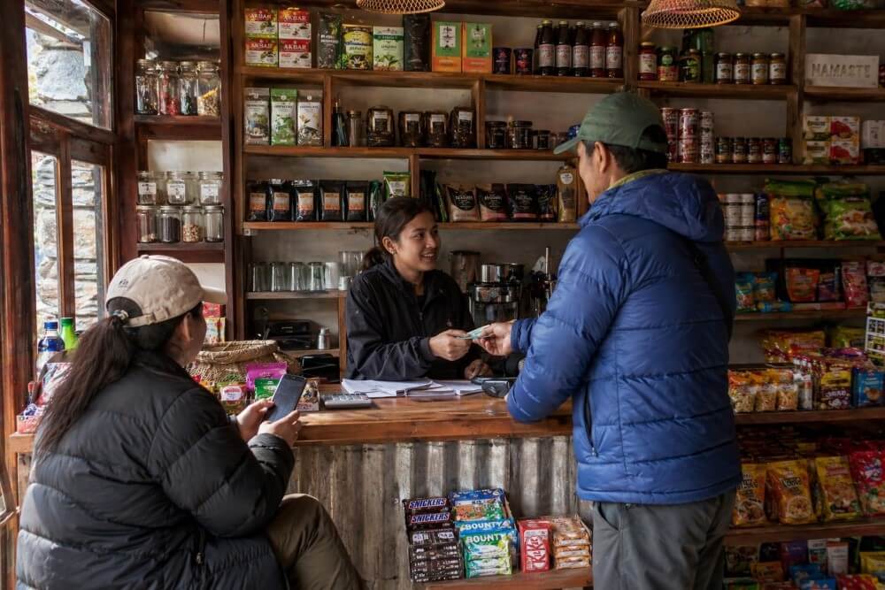 Nepali bezahlt in einem kleinen Local-Laden mit Bargeld.