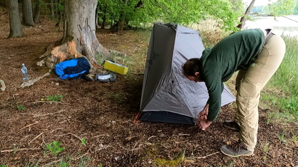 Wanderer befestigt das Außenzelt des Decathlon MT900.