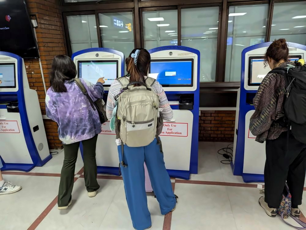 Reisende vor Visa on Arrival Kiosk am Flughafen in Kathmandu.